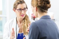 Patient speaking with doctor about health care procedures and insurance coverage