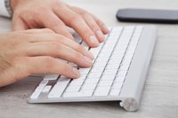 Man's hand on a computer keyboard