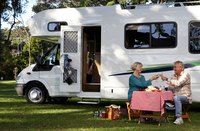 Mature couple eating a meal outside their mobile home