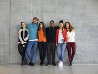 Diverse group of individuals leaning against wall