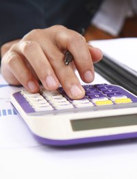 Close-up of a hand typing on a calculator