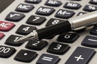 Close-up of pen sitting on top of calculator
