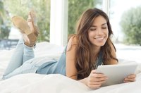 A young woman reading on her tablet computer