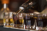 Row of shot glasses being filled