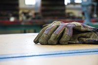 A close-up of work gloves on a bench in a shop.