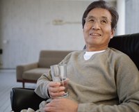 Mature man holding a glass of water.