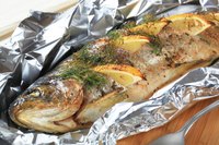 Baked trout stuffed with lemon and wrapped in foil
