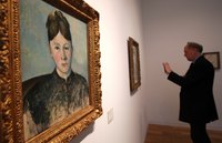 A painting by Cezanne hangs in a gallery.