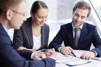 Three business colleagues discuss financial documents