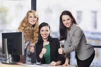 Employees giving thumbs up at desk