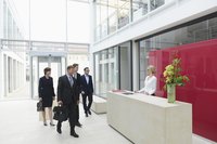 Receptionist welcomes a group of business people.