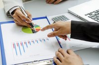 Two businesswomen analyzing a financial pie chart.