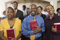 Members of a church hold their bibles while standing.