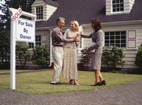 Real estate agent handing mature couple a set of keys.