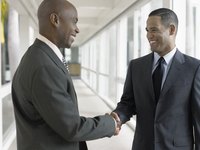 Two businessmen shaking hands in hallway