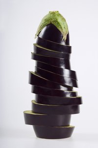 Top oven-baked eggplant slices with Parmesan cheese to create a savory snack.