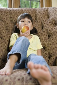 A young girl is eating an apple.