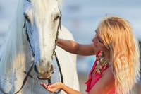 A horse rejecting a snack from a concerned woman.
