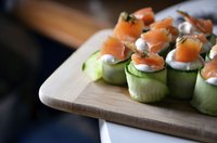 Smoked salmon with cucumber appetizer prepared by a caterer.