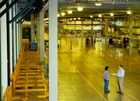 Two people talking inside a warehouse.