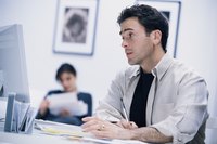 Young adult man creating an invoice on his computer