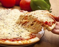 Hand taking a slice of cheese pizza.