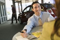 A man is talking to a car salesman.