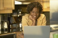 Woman using laptop in the kitchen.