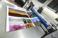 A poster being printed on a machine in a print shop.