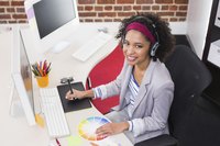 A designer smiling while working at an office desk.