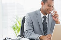 Businessman using laptop while on phone