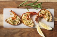 Dress halved lobster tails with herbed butter and lemon juice after broiling.