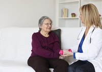 Occupational therapist with senior holding weight
