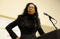 A woman speaking at a podium during a conference.