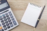 Calculator beside notepad on table