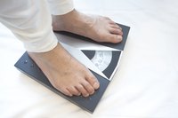 A close-up of a man standing and weighing himself on a scale.