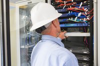 An IT worker is checking a server rack.