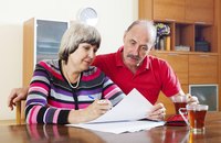 A mature woman and man are filling out forms.