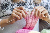Woman's hands knitting a scarf.