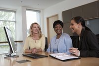 Three business women are doing administrative office work.