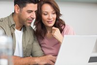 Couple of home owners reading on laptop