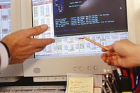 A close-up of two people analyzing data on a computer screen.