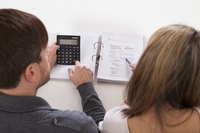 A couple creates a budget together at a table.