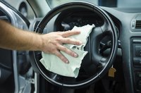 Image of a man using a microfiber towel to clean his steering wheel.