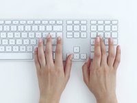 Hands typing on a computer keyboard
