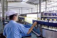A worker inspects an assembly line.