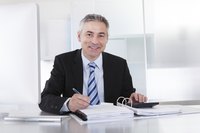 Businessman filling out paperwork at desk