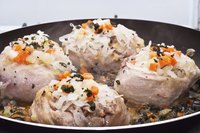 Veal shanks cooking in a frying pan.