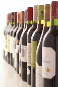 Empty wine bottles form an interesting collection atop kitchen cabinets.