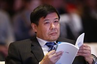 An economist reading a booklet at a conference.